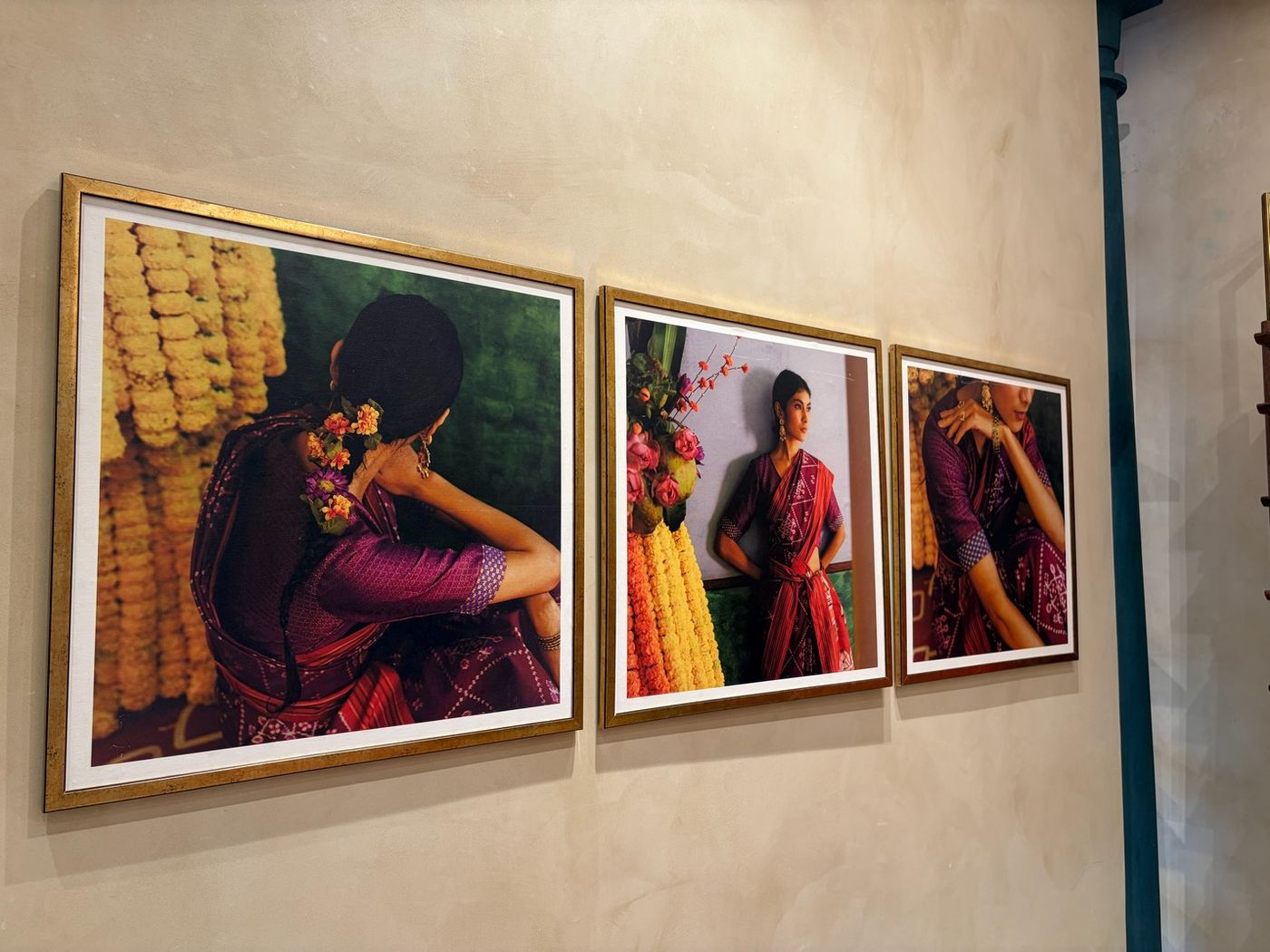 Framed photographs of handloom sarees styled with marigold garlands