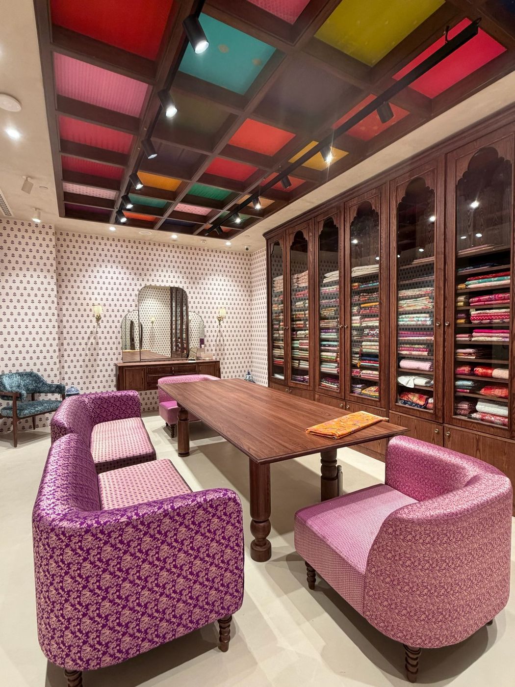 Private saree selection lounge with brocade seating and a coloured glass coffered ceiling