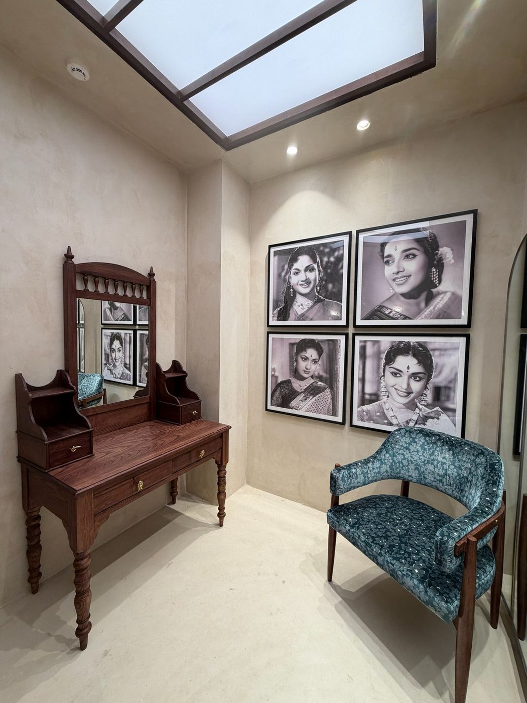 Vintage teak dressing table and mirror beneath framed portraits of classic Telugu film actresses